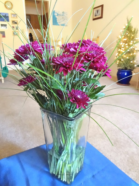 burgundy flowers with green grass in a vase