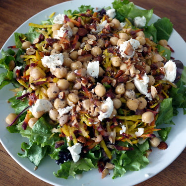 Spring salad with greens, shredded root veg, chickpeas, goat cheese, and almonds