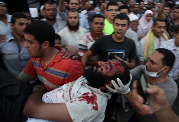 Photo: AP Supporters of Egypt's ousted President Mohammed Morsi carry an injured man to a field hospital following clashes with security forces at Nasr City, where pro-Morsi protesters have held a weekslong sit-in, in Cairo, Egypt, Saturday, July 27, 2013. Police fired tear gas to disperse hundreds of Morsi supporters, setting off clashes that lasted for hours and left tens of people dead (think in pictures @1WORLDCommunity)