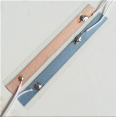 Four wires crudely soldered onto a length of copper tape.