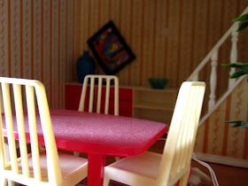 Messy vintage Lundby dolls house dining room with dusty furniture and a picture falling off the wall.