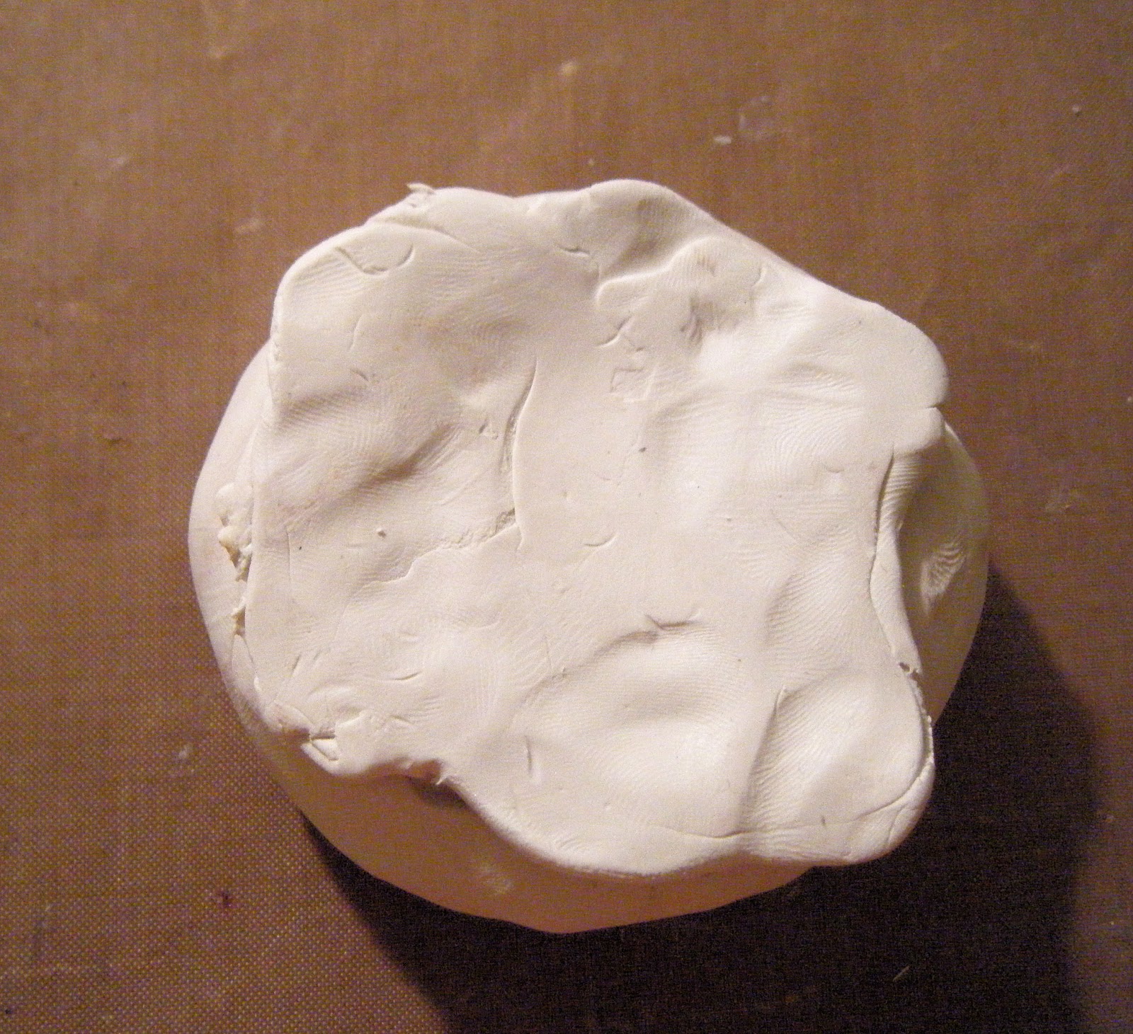 Very gently and carefully so as not to tear the clay but firmly I