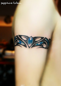 tribal totem arm ring tattoo with sapphire