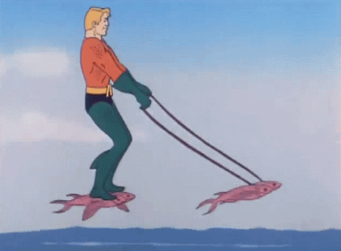 Animated gif of Aquaman riding flying fish by standing with one foot on each, and then steering using two more flying fish attached to reins.