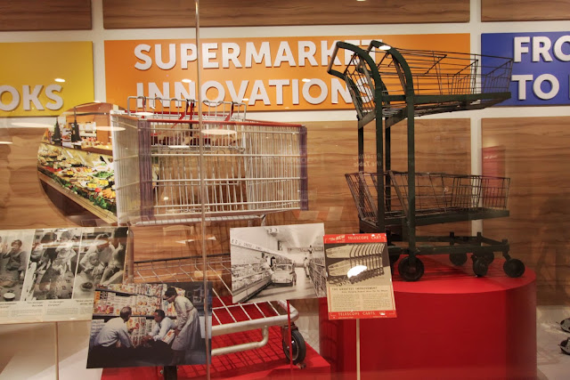 Small shopping cart or trolley in the early days compared to the current big shopping cart at National Museum of American History in Washington DC, USA Small shopping cart or trolley in the early days compared to the current big shopping cart at National Museum of American History in Washington DC, USA