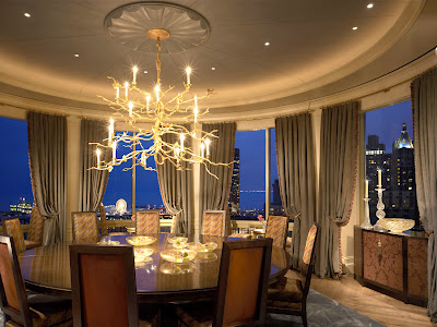 luxurious and stunning round room of dining room luxurious and stunning round room of dining room which includes round dining table and comfy chairs, stunning gold finished chandeliers, accent soft curtains and view to the city