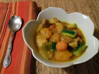 Individual serving of curried pork and pumpkin stew