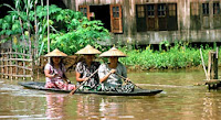 Three women in small wooden canoe