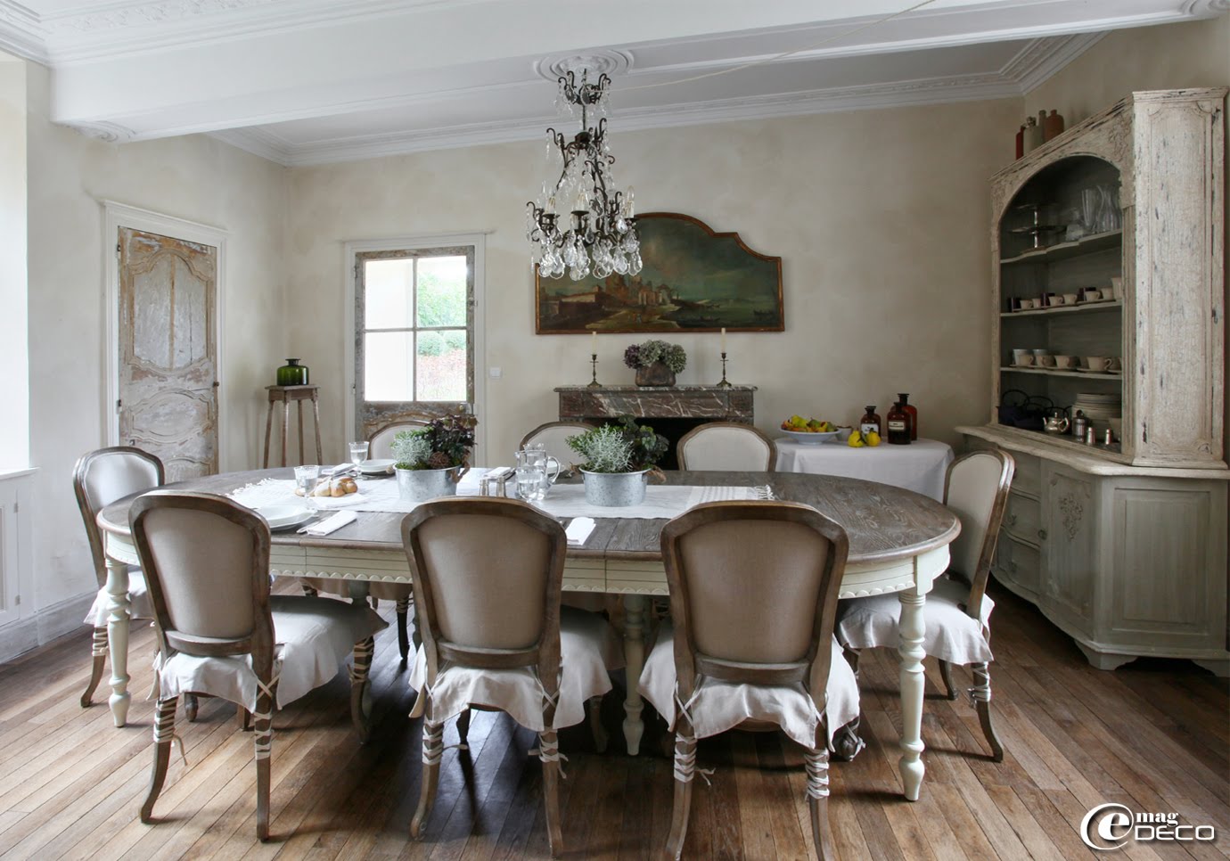 Dans la salle à manger de la maison d'hôtes 'Hôtel de Suhard', lustre à pampilles de verre 'Labyrinthe interiors', table 'Blanc d’Ivoire' et chaises 'Camille Bertrand'