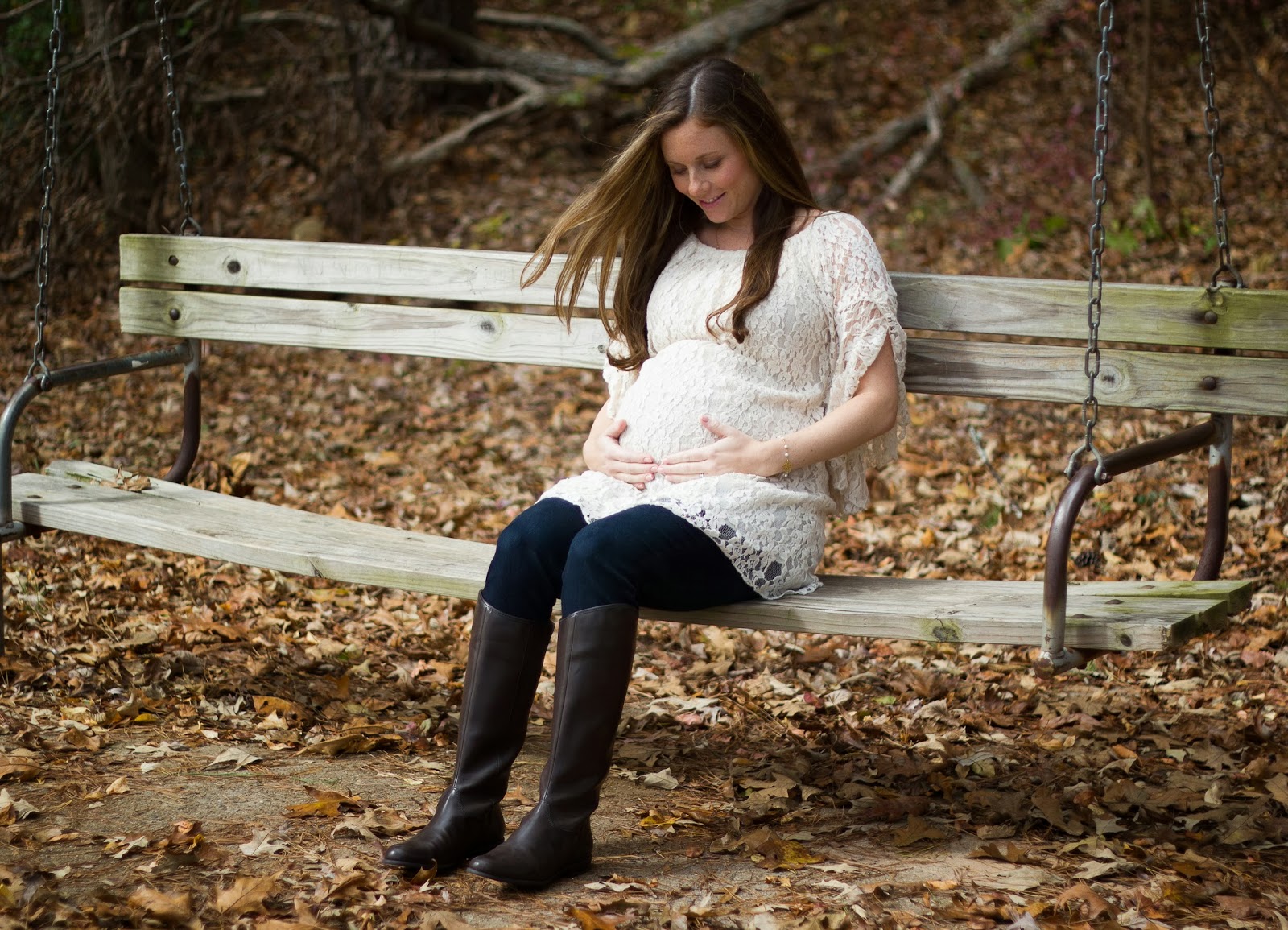 fall maternity shoot mom wearing lace dress and knee high boots at park