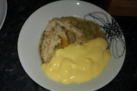 a dish containing a portion of rhubarb and loquat crumble with a serving of hot custard too.