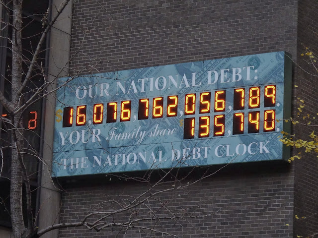 Passing through a huge electronic billboard on a building in Manhattan where it shows the current total USA debt during Autumn 2012 in New York, USA Passing through a huge electronic billboard on a building in Manhattan where it shows the current total USA debt during Autumn 2012 in New York, USA
