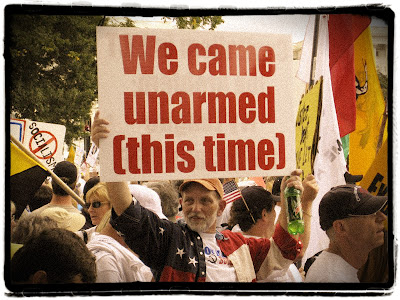 Tea Partier with sign reading, 'We came unarmed (this time)'