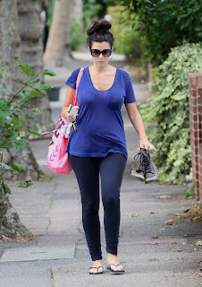Imogen Thomas carrying a pair of boots in her hand