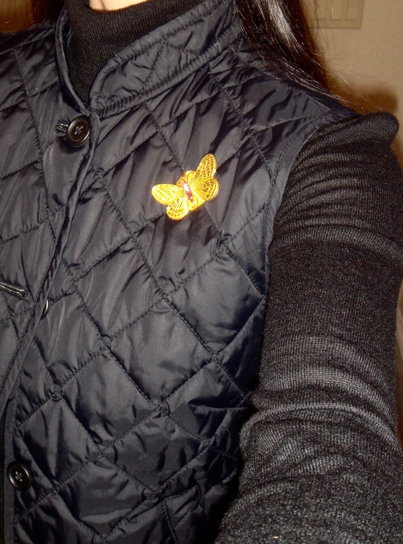 Brooch on Quilted Vest Close Up Close up of vintage gold butterfly brooch pinned on the quilted vest.
