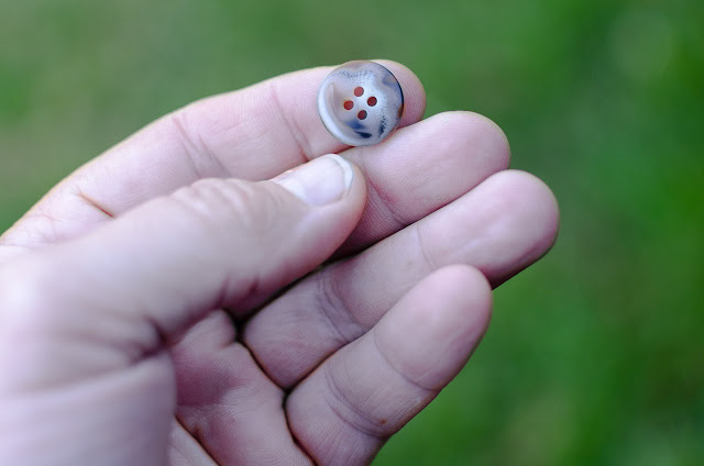 Button popped holding button in hand