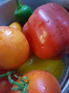 bowl full of washed veggies; colorful peppers and tomatoes