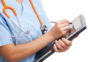 Nurse writing on a digital tablet computer