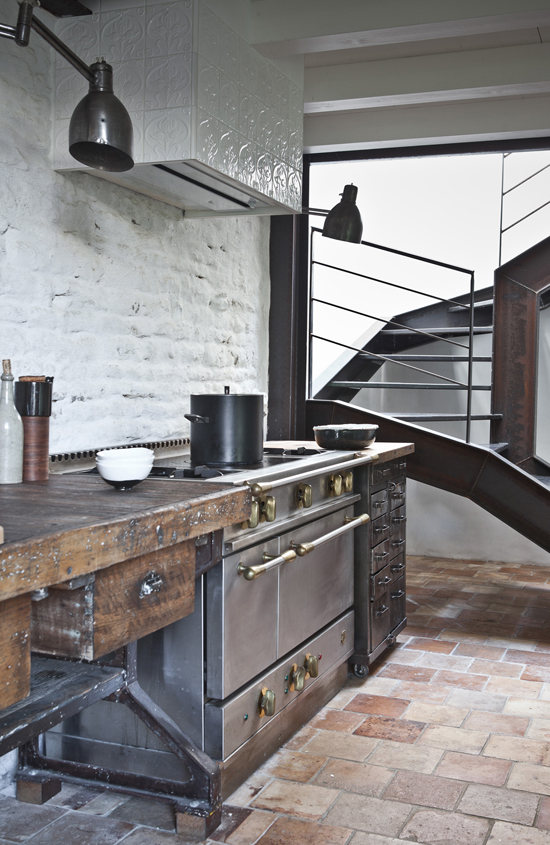 A pair of industrial sconces couldn't miss from the amazing statement kitchen in Isis-Colombe Combréas summer house