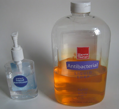 large bottle of orange liquid soap next to smaller bottle of clear hand sanitizer