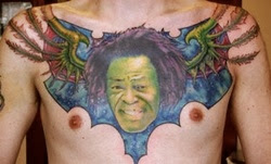 se tatua un rostro verde con alas de murcielago en el pecho