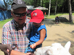 Alexandre and Grand-papa Guy feeding the goat