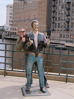 a man posing with a statue of a man
