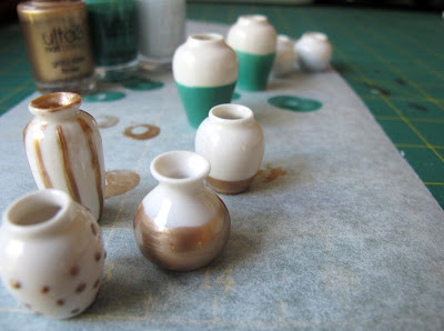 Selection of white dolls' house vases decorated with nail varnish.