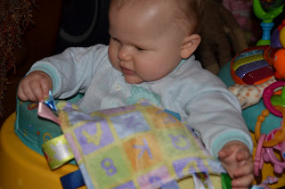 Baby playing with a taggie blanket