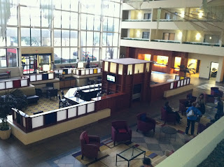 a room with many windows and a large area with chairs and tables