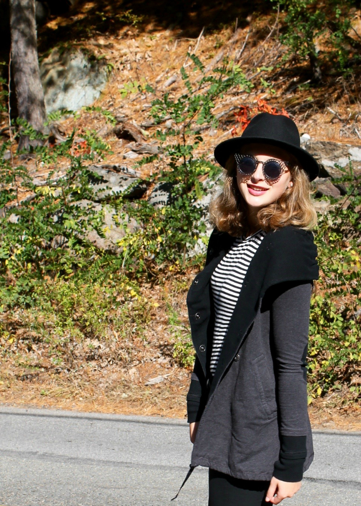 Black outfit with a Lululemon vest and fedora