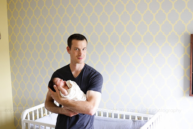 A daddy holding his newborn son in the nursery