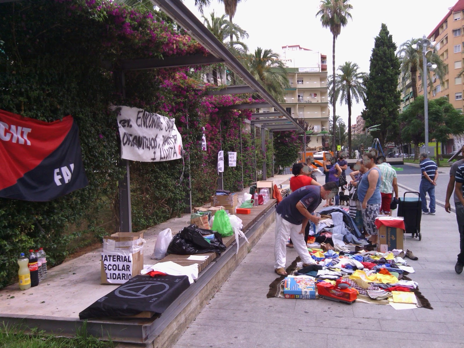 CRÓNICA DEL 1er ENCUENTRO SOLIDARIO Tras unas semanas de trabajo y esfuerzo de los compañeros y compañeras, quedaban ya unas pocas horas para empezar con el Encuentro Solidario organizado desde CNT-La Safor, el grupo anarquista Camilo Berneri, de la FAI, y el grupo anarquista Los Solidarios. Habíamos recogido ropa, material escolar, libros, comida y diferentes enseres como algún juguete o gatos para automóvil. También teníamos a punto diferentes panfletos, folletos y pancartas. En efecto, finalmente teníamos con qué empezar y dar impulso a la jornada, pero aun así sabíamos que nos dejábamos muchas cosas pendientes. Sin embargo este primer encuentro sería solamente el pistoletazo de salida, el primer paso del largo camino sobre el que deberemos actuar, reflexionar, y corregir si hiciese falta antes de volver a dar el siguiente paso. Hacia bien entrado el mediodía del viernes, a menos de 24 horas del encuentro el ayuntamiento advirtió a una de las compañeras que no iba a consentir que nos emplazáramos en el lugar elegido para llevar a cabo esta jornada. Pero como su ley no es justicia ni ley natural, sino autoritarismo y exterminio, tampoco íbamos a hacer caso de los balidos del alcalde y su manada. De todas maneras, siendo poco más de las ocho de la mañana del sábado, no sabíamos con qué íbamos a encontrarnos y las dudas corroían nuestras mentes… ¿la jornada tendría unos resultados satisfactorios? ¿comprendería el barrio qué estábamos haciendo y por qué? ¿cómo lo aceptarían? Llegó el momento y llegamos a la plaza Elíptica para desplegar todos los bultos y cajas que traíamos. La bandera rojinegra observaba expectante cómo íbamos distribuyendo la ropa, los zapatos, los folletos, los libros… Gandía aún estaba terminando de despertar y sus calles a duras penas eran invadidas por unos pocos pares de pies que paseaban apresurados. Y llegó el primer vecino, un hombre que terminaba su jornada de trabajo como celador y que, a sabiendas del encuentro, se acercó a traer una bolsa con comida sin llevarse nada a cambio. Poco a poco iba acercándose más gente. Se sorprendían al ver ropa nueva con etiquetas (una tienda de ropa que cerró nos donó una importante cantidad de ropa infantil y adulta sin estrenar). “¿Cuánto cuesta ésto?”, preguntaba algún despistado o despistada. Había carteles que describían el sencillo funcionamiento del encuentro: “coge lo que necesites”, y a quien pudiere, “trae lo que puedas”, pero la próxima vez lo pondremos más grande y más claro. Otra niña se llevó unos libros de secundaria y al poco rato volvió para traer los que ella ya había usado anteriormente para poder compartirlos. Otros chicos bajaron cargados con cajas y bolsas, y se iban formando pequeños corrillos de gente que, entre agradecimientos, comentarios y razonamientos, medio llenaban esta zona de la plaza. En medio de este ambiente fraternal y solidario llegaron compañeros de la CNT de los sindicatos de Sagunto, Albaida y Valencia, y la alegría se multiplicó. Estos compañeros recorrieron distancias considerables con el llano y noble objetivo de echarnos una mano, es decir, de currar toda la mañana junto con nosotras y nosotros. En esos momentos es cuando verdaderamente me llena de orgullo y emoción pertenecer a la CNT. Todas las dudas que albergábamos en las primeras horas del día se fueron disipando a medida que avanzaba la mañana. Los resultados fueron mucho mejores de lo esperados: muchas familias humildes del barrio se pudieron beneficiar de esta jornada además de empezar a establecer lazos de simpatía y solidaridad entre todos y todas las presentes; otras familias también ejercieron esta solidaridad al compartir aquello que bienintencionadamente podían; y hubo otras personas que se interesaron por la faceta ideológica del encuentro, llevándose algunos folletos y preguntando sobre algunos aspectos de la situación actual y el punto de vista libertario. Algún anciano desmemoriado, porque enterró la memoria y no porque la perdió, pasó refunfuñando que hacían falta tres Franco y un Hitler para limpiarlo todo de tanto sinvergüenza. No le dimos mayor importancia de la que tiene mirar cómo defeca un cerdo. Luego llegó una pareja de policías rebuznando que unos vecinos se habían quejado y nos instaron primero a marcharnos, y ante la negativa, a quitar las pancartas (que rezaban oraciones como “Rodrigo Rata”), pero finalmente no se movió nada del sitio. Llegó el mediodía y después de estar horas soportando el tórrido sol, que tuvo la osadía de aparecer de entre las nubes a media mañana, empezamos a recoger. La gente empezaba ya a refugiarse en sus casas huyendo del calor y buscando un plato de comida y tal vez una siesta con ventilador, tales son las vacaciones del pobre y del trabajador. Tan grande fue la solidaridad del barrio, que al terminar nos fuimos con más bultos de los que trajimos, así que deberemos repetir esta jornada, evaluando bien la primera experiencia para corregir errores y mejorar en nuestro camino hacia la organización popular desde una perspectiva libertaria. Al terminar las compañeras y compañeros acudimos a un pequeño huerto de uno de los compañeros del sindicato local y, en un pequeño oasis que una sombra de un cobertizo de cañas formaba en medio del campo, degustamos una sabrosa paella echa a leña, culminando la jornada entre conversaciones cómicas y debates serios, entre recuerdos pasados e ilusiones futuras, y todo ello inmerso en un fraternal y cálido ambiente refrescado por la brisa marina del litoral gandiense. Ante todo lo expuesto, repetiremos esta jornada, no quepa duda, habiendo localizado algunos aspectos que deberemos mejorar. El siguiente encuentro terminará de consolidar lazos entre el vecindario, haciendo cada vez más posible una organización popular. Nosotros, los anarquistas, estamos al lado del pueblo para luchar contra los ataques que a todos nos impiden vivir dignamente y en plena libertad, no estamos a su lado para decirles cómo deben de actuar. Nunca podremos llevar a cabo una Revolución Social Libertaria sin el levantamiento del pueblo, y el pueblo no puede defender la causa libertaria si no sabe en qué consiste, qué defiende y por qué lucha. Para gran parte de este pueblo, las y los anarquistas aún somos los vagos, los maleantes, violentos y terroristas, quienes queremos que todo sea de todos para vivir a costa de quienes trabajan, pero nosotras y nosotros sabemos que eso no es en absoluto cierto. La libertad no se piensa, no se explica, no se define… la libertad se siente dentro, impulsa nuestro corazón y dirige los movimientos de nuestro cuerpo. Y si no contagiamos al pueblo este sentimiento de libertad nos veremos destinados a vivir a sus espaldas y bajo el yugo común del Estado. Sí, ahora sí que no tenemos duda alguna: el segundo encuentro será mucho mejor, y por supuesto ampliaremos los objetivos que nos planteemos para esa jornada y, con ello, las acciones que la completarán. Pero no adelantemos acontecimientos. Continuaremos informando sobre este tipo de encuentros. Salud, libertad y Revolución Social. CNT-La Safor Grupo Anarquista Los Solidarios Grupo Anarquista Camilo Berneri – FAI CRÓNICA DEL 1er ENCUENTRO SOLIDARIO Tras unas semanas de trabajo y esfuerzo de los compañeros y compañeras, quedaban ya unas pocas horas para empezar con el Encuentro Solidario organizado desde CNT-La Safor, el grupo anarquista Camilo Berneri, de la FAI, y el grupo anarquista Los Solidarios. Habíamos recogido ropa, material escolar, libros, comida y diferentes enseres como algún juguete o gatos para automóvil. También teníamos a punto diferentes panfletos, folletos y pancartas. En efecto, finalmente teníamos con qué empezar y dar impulso a la jornada, pero aun así sabíamos que nos dejábamos muchas cosas pendientes. Sin embargo este primer encuentro sería solamente el pistoletazo de salida, el primer paso del largo camino sobre el que deberemos actuar, reflexionar, y corregir si hiciese falta antes de volver a dar el siguiente paso. Hacia bien entrado el mediodía del viernes, a menos de 24 horas del encuentro el ayuntamiento advirtió a una de las compañeras que no iba a consentir que nos emplazáramos en el lugar elegido para llevar a cabo esta jornada. Pero como su ley no es justicia ni ley natural, sino autoritarismo y exterminio, tampoco íbamos a hacer caso de los balidos del alcalde y su manada. De todas maneras, siendo poco más de las ocho de la mañana del sábado, no sabíamos con qué íbamos a encontrarnos y las dudas corroían nuestras mentes… ¿la jornada tendría unos resultados satisfactorios? ¿comprendería el barrio qué estábamos haciendo y por qué? ¿cómo lo aceptarían? Llegó el momento y llegamos a la plaza Elíptica para desplegar todos los bultos y cajas que traíamos. La bandera rojinegra observaba expectante cómo íbamos distribuyendo la ropa, los zapatos, los folletos, los libros… Gandía aún estaba terminando de despertar y sus calles a duras penas eran invadidas por unos pocos pares de pies que paseaban apresurados. Y llegó el primer vecino, un hombre que terminaba su jornada de trabajo como celador y que, a sabiendas del encuentro, se acercó a traer una bolsa con comida sin llevarse nada a cambio. Poco a poco iba acercándose más gente. Se sorprendían al ver ropa nueva con etiquetas (una tienda de ropa que cerró nos donó una importante cantidad de ropa infantil y adulta sin estrenar). “¿Cuánto cuesta ésto?”, preguntaba algún despistado o despistada. Había carteles que describían el sencillo funcionamiento del encuentro: “coge lo que necesites”, y a quien pudiere, “trae lo que puedas”, pero la próxima vez lo pondremos más grande y más claro. Otra niña se llevó unos libros de secundaria y al poco rato volvió para traer los que ella ya había usado anteriormente para poder compartirlos. Otros chicos bajaron cargados con cajas y bolsas, y se iban formando pequeños corrillos de gente que, entre agradecimientos, comentarios y razonamientos, medio llenaban esta zona de la plaza. En medio de este ambiente fraternal y solidario llegaron compañeros de la CNT de los sindicatos de Sagunto, Albaida y Valencia, y la alegría se multiplicó. Estos compañeros recorrieron distancias considerables con el llano y noble objetivo de echarnos una mano, es decir, de currar toda la mañana junto con nosotras y nosotros. En esos momentos es cuando verdaderamente me llena de orgullo y emoción pertenecer a la CNT. Todas las dudas que albergábamos en las primeras horas del día se fueron disipando a medida que avanzaba la mañana. Los resultados fueron mucho mejores de lo esperados: muchas familias humildes del barrio se pudieron beneficiar de esta jornada además de empezar a establecer lazos de simpatía y solidaridad entre todos y todas las presentes; otras familias también ejercieron esta solidaridad al compartir aquello que bienintencionadamente podían; y hubo otras personas que se interesaron por la faceta ideológica del encuentro, llevándose algunos folletos y preguntando sobre algunos aspectos de la situación actual y el punto de vista libertario. Algún anciano desmemoriado, porque enterró la memoria y no porque la perdió, pasó refunfuñando que hacían falta tres Franco y un Hitler para limpiarlo todo de tanto sinvergüenza. No le dimos mayor importancia de la que tiene mirar cómo defeca un cerdo. Luego llegó una pareja de policías rebuznando que unos vecinos se habían quejado y nos instaron primero a marcharnos, y ante la negativa, a quitar las pancartas (que rezaban oraciones como “Rodrigo Rata”), pero finalmente no se movió nada del sitio. Llegó el mediodía y después de estar horas soportando el tórrido sol, que tuvo la osadía de aparecer de entre las nubes a media mañana, empezamos a recoger. La gente empezaba ya a refugiarse en sus casas huyendo del calor y buscando un plato de comida y tal vez una siesta con ventilador, tales son las vacaciones del pobre y del trabajador. Tan grande fue la solidaridad del barrio, que al terminar nos fuimos con más bultos de los que trajimos, así que deberemos repetir esta jornada, evaluando bien la primera experiencia para corregir errores y mejorar en nuestro camino hacia la organización popular desde una perspectiva libertaria. Al terminar las compañeras y compañeros acudimos a un pequeño huerto de uno de los compañeros del sindicato local y, en un pequeño oasis que una sombra de un cobertizo de cañas formaba en medio del campo, degustamos una sabrosa paella echa a leña, culminando la jornada entre conversaciones cómicas y debates serios, entre recuerdos pasados e ilusiones futuras, y todo ello inmerso en un fraternal y cálido ambiente refrescado por la brisa marina del litoral gandiense. Ante todo lo expuesto, repetiremos esta jornada, no quepa duda, habiendo localizado algunos aspectos que deberemos mejorar. El siguiente encuentro terminará de consolidar lazos entre el vecindario, haciendo cada vez más posible una organización popular. Nosotros, los anarquistas, estamos al lado del pueblo para luchar contra los ataques que a todos nos impiden vivir dignamente y en plena libertad, no estamos a su lado para decirles cómo deben de actuar. Nunca podremos llevar a cabo una Revolución Social Libertaria sin el levantamiento del pueblo, y el pueblo no puede defender la causa libertaria si no sabe en qué consiste, qué defiende y por qué lucha. Para gran parte de este pueblo, las y los anarquistas aún somos los vagos, los maleantes, violentos y terroristas, quienes queremos que todo sea de todos para vivir a costa de quienes trabajan, pero nosotras y nosotros sabemos que eso no es en absoluto cierto. La libertad no se piensa, no se explica, no se define… la libertad se siente dentro, impulsa nuestro corazón y dirige los movimientos de nuestro cuerpo. Y si no contagiamos al pueblo este sentimiento de libertad nos veremos destinados a vivir a sus espaldas y bajo el yugo común del Estado. Sí, ahora sí que no tenemos duda alguna: el segundo encuentro será mucho mejor, y por supuesto ampliaremos los objetivos que nos planteemos para esa jornada y, con ello, las acciones que la completarán. Pero no adelantemos acontecimientos. Continuaremos informando sobre este tipo de encuentros. Salud, libertad y Revolución Social. CNT-La Safor Grupo Anarquista Los Solidarios Grupo Anarquista Camilo Berneri – FAI