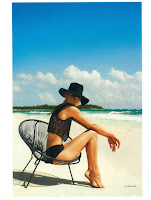 Doutzen Kroesin black swimwear sitting in a chair at the beach