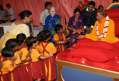 Jagadguru Kripaluji Maharaj giving uniforms to girl students