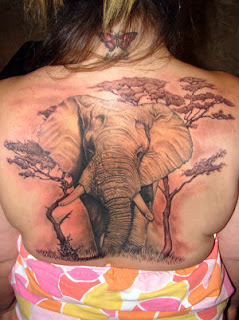 Large Back Pice Elephant Tattoo on Girl. Also Check out the Butterfly Tattoo design on the neck.