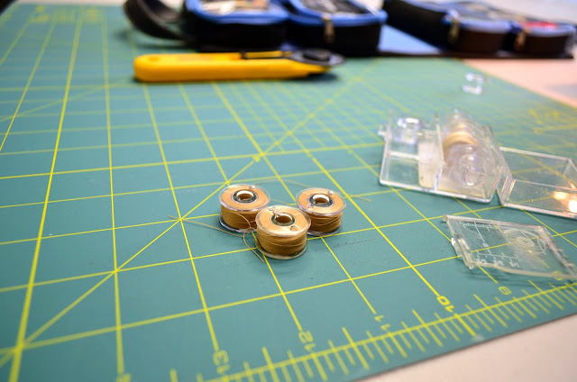 The fruits of my labor? A plastic case of eight, Aurifil-2314-filled bobbins.