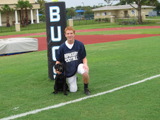 Here is Austin in his uniform with Coach. Austin is posing by the fieldgoal as he is the teams kicker. Here is Austin in his uniform with Coach. Austin is posing by the fieldgoal as he is the teams kicker.