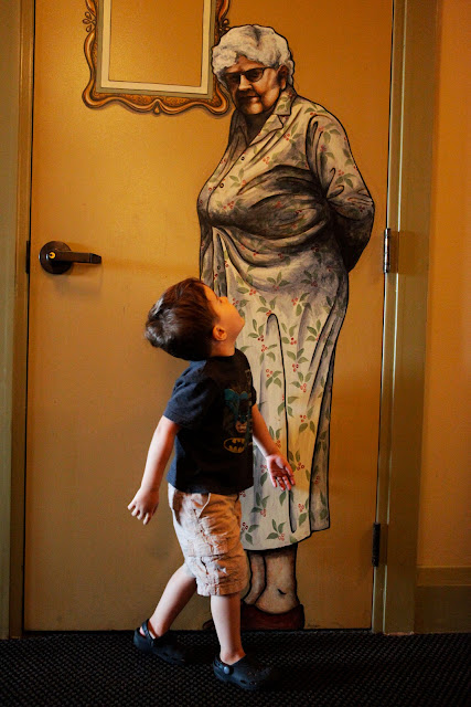 A young boy looking up at a door mural inside McMenamins Grand Lodge in Oregon.
