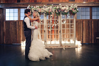 Tyler and Megan in front of their ceremony triptych. Megan and Tyler standing before their wedding ceremony triptych.
