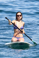 Olivia Wilde on her knees on a paddle board