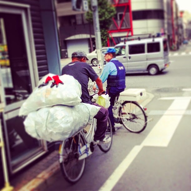 Homeless man and police on bicycles, Asakusabashi, Tokyo Homeless person and policeman on bicycles, Asakusabashi, Tokyo
