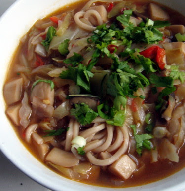 fresh ramen noodles in broth with oyster mushrooms and cabbage