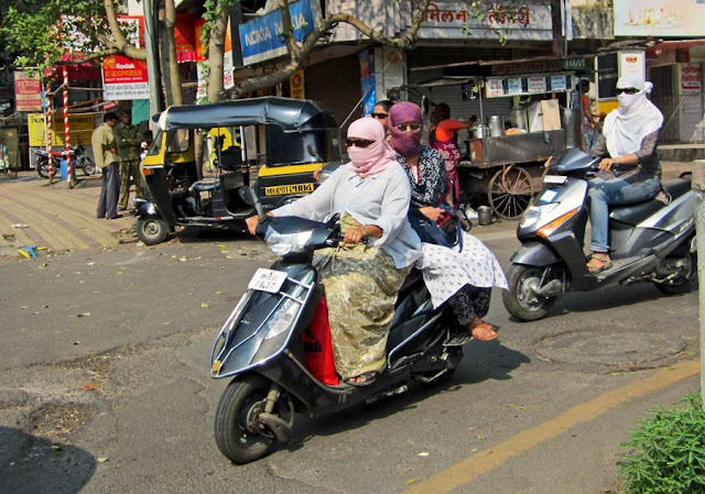 masked women riding a scooter in Pune