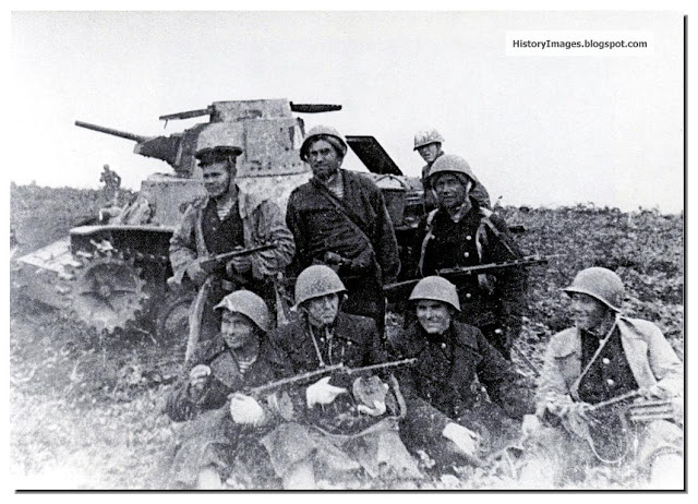 Russian soldiers pose against a destroyed Japanese tank on Shumshu Islands (in the Kuril Islands)