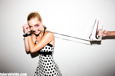 Heather Morris with black eye, arms bound by iron cord