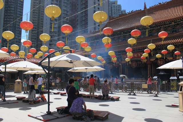 A close view of visitors worship with burning intense sticks and practicing kau cim at Wong Tai Sin Temple in Kowloon, Hong Kong A close view of visitors worship with burning intense sticks and practicing kau cim at Wong Tai Sin Temple in Kowloon, Hong Kong