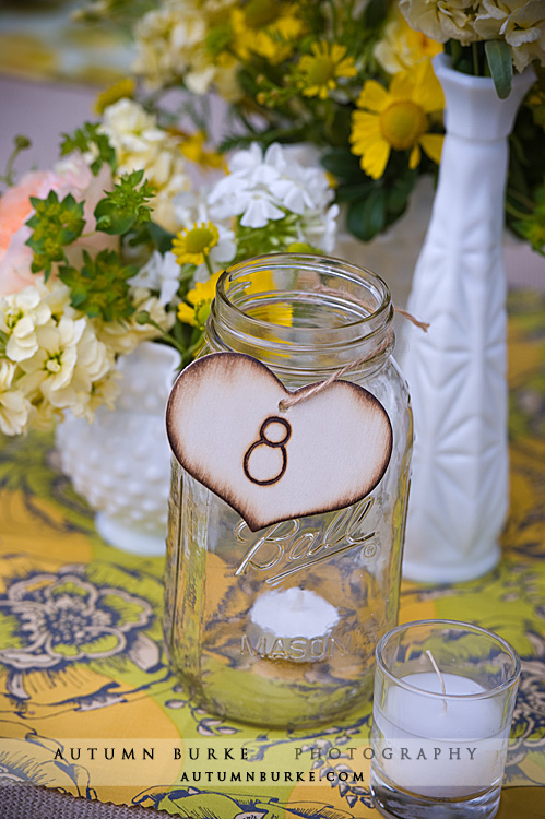 Each centerpiece had a variety of white milk glass filled with yellow and Each centerpiece had a variety of white milk glass filled with yellow and