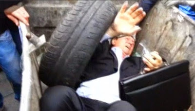 Ex-minister thrown into rubbish bin by angry mob (photos)
