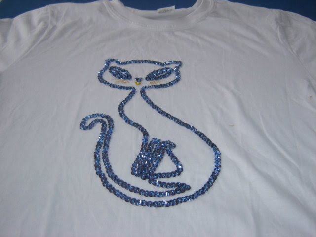 camiseta com gatinho.Feito com lantejoulas azuis.